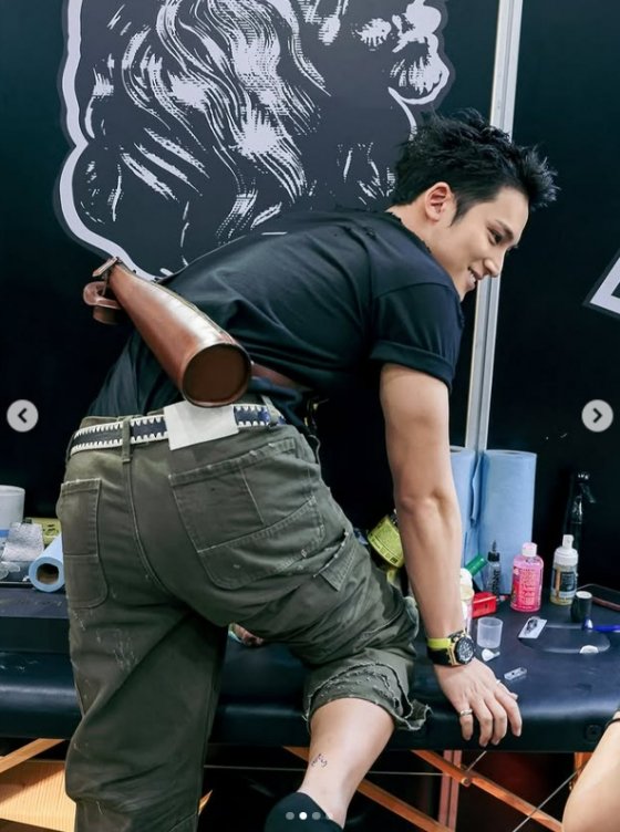 Mingyu shows off his ankle tattoo at a tattoo shop